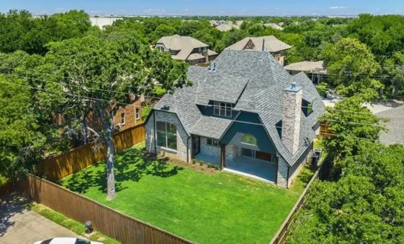 Aerial view of a limestone custom home among mature trees